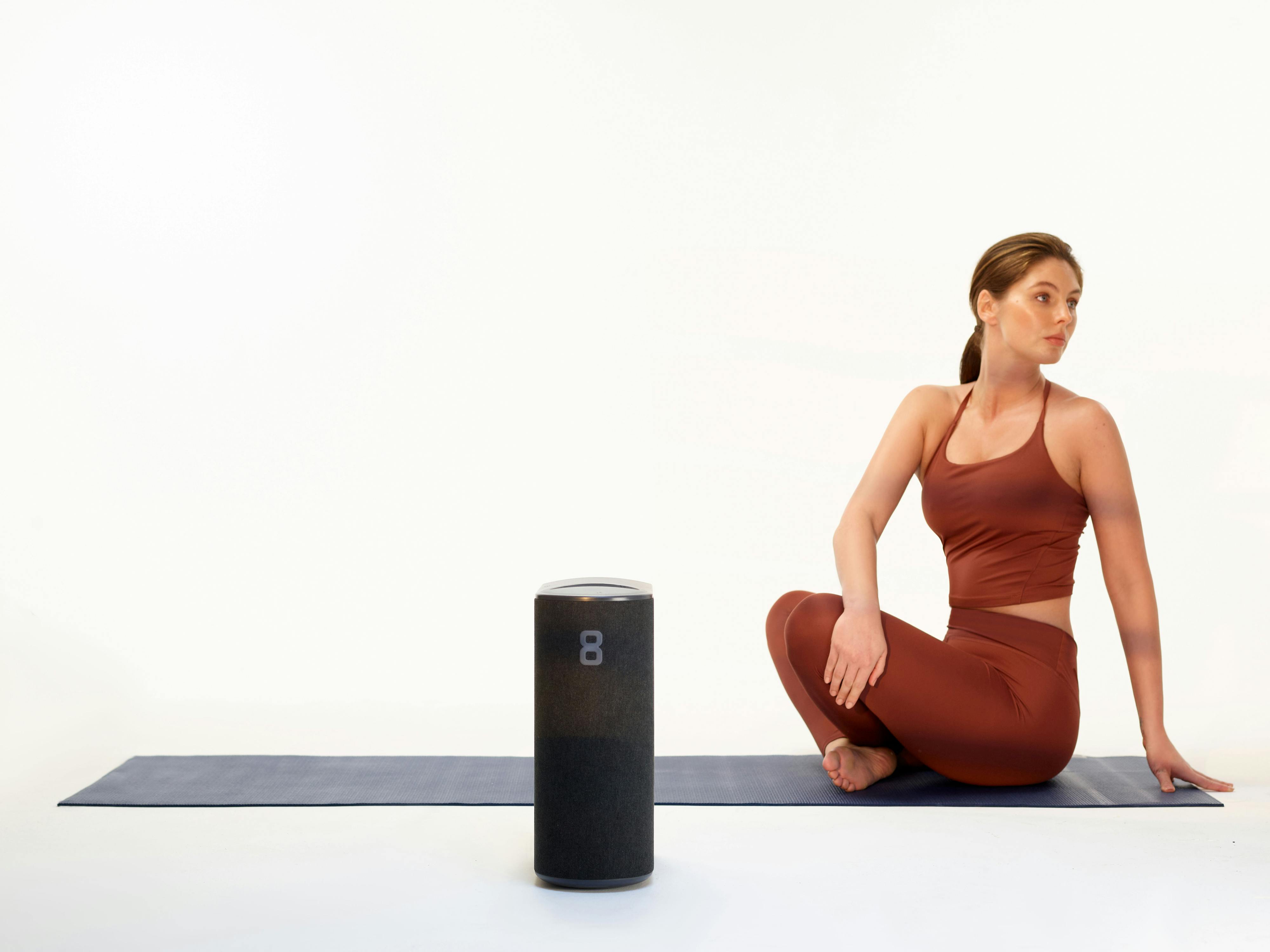 A woman doing yoga next to the Pod 4 Hub